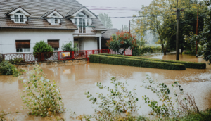 Flooded residential property with water surrounding the house, highlighting potential water damage risks and insurance claim considerations.