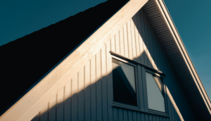 Roof corner of a house with a window, highlighting potential areas for water damage assessment related to insurance claims.